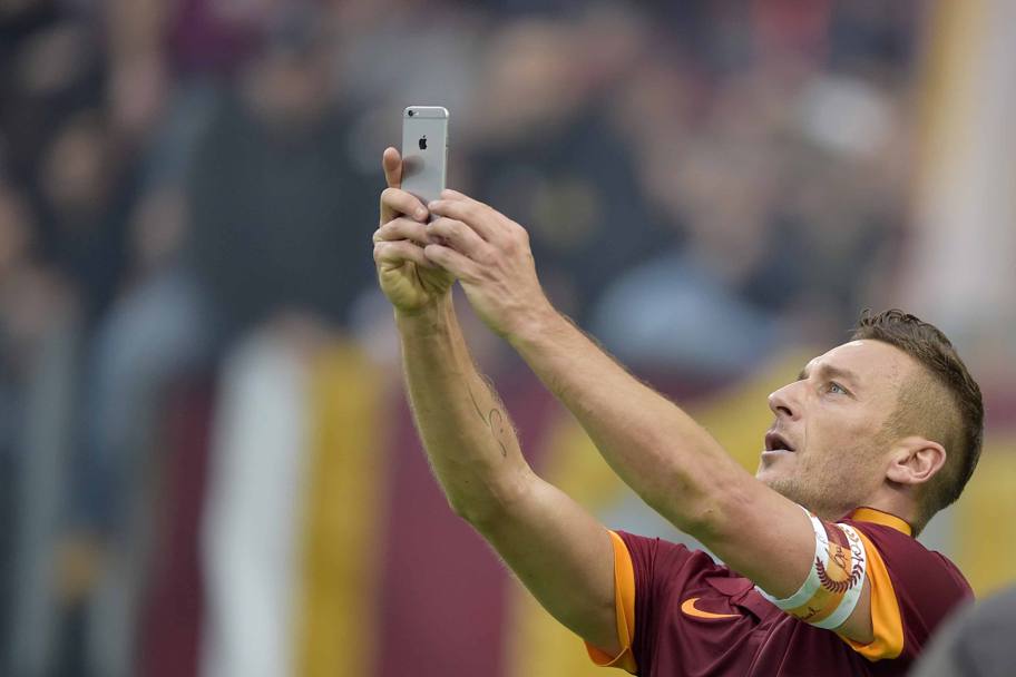 11 gennaio 2015 - Roma-Lazio 2-2. L&#39;esultanza che ha fatto il giro del web: Francesco Totti impugna un telefonino e scatta un selfie sullo sfondo della curva sud (LaPresse)